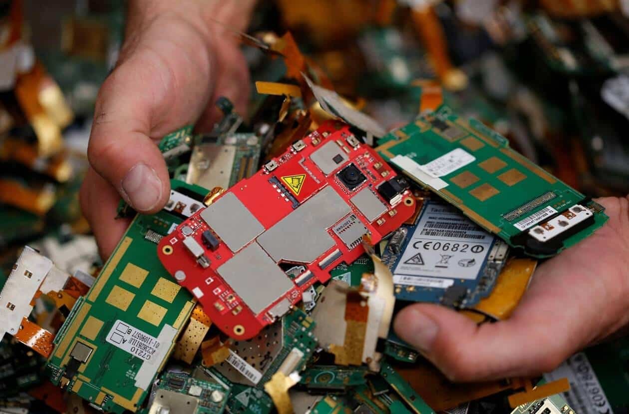 A worker of Ecomicro recycling company selects computer cards of old cell phones in Saint Loubes near Bordeaux, Southwestern France