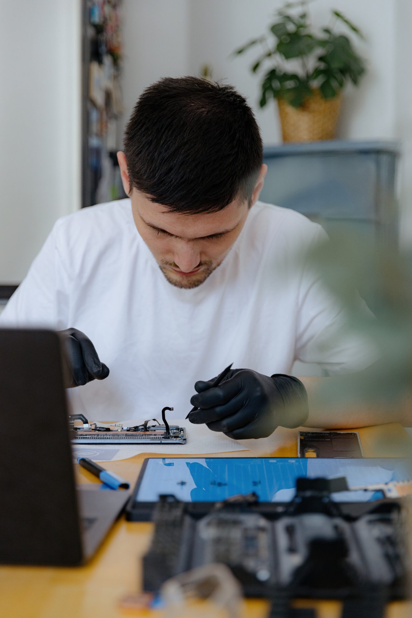 A young man repairs a smartphone at home.